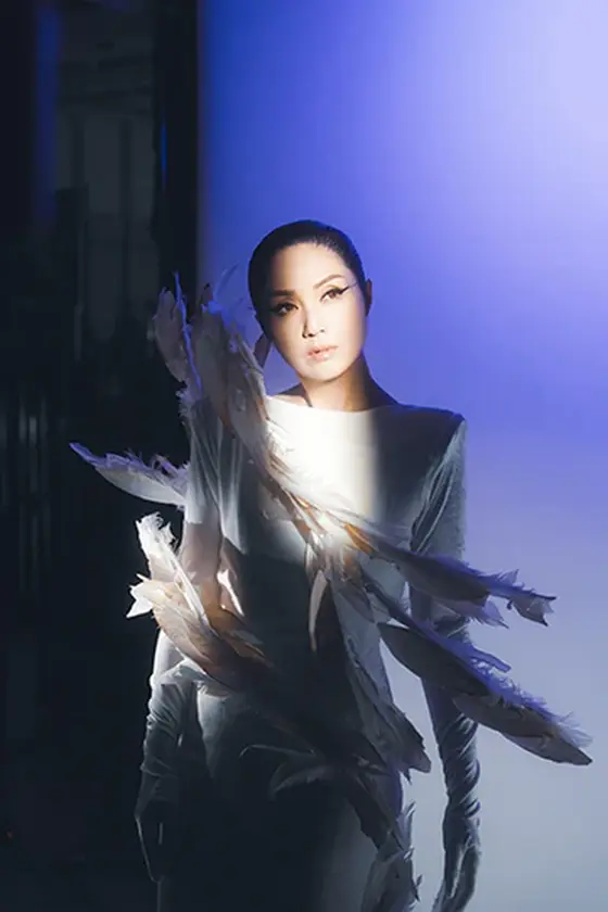 Miriam Yeung in a feathered gown against violet light